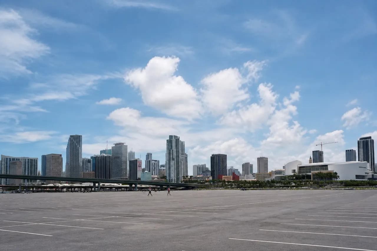Wide asphalt parking apron under a hot South Florida sky