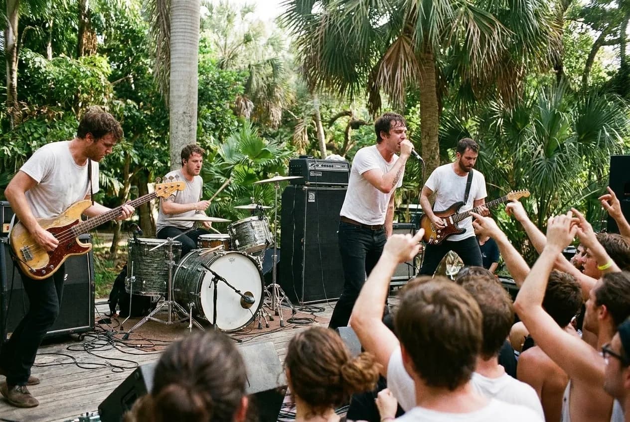 A band mid-set on a low stage, the front row within arm's reach