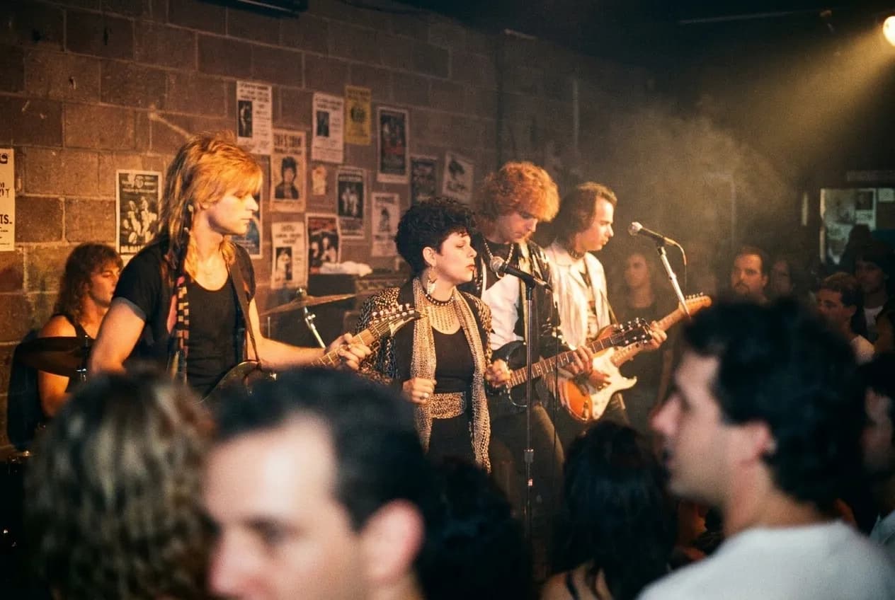 Band playing on a small stage in a dimly lit music venue