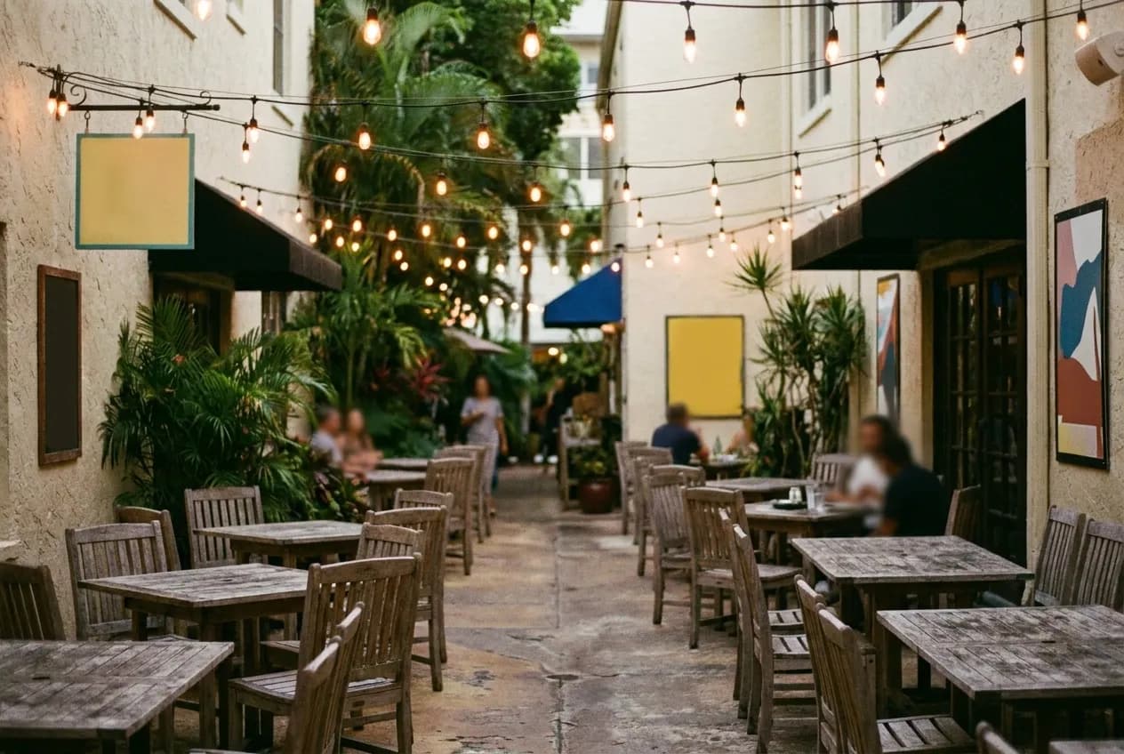 A courtyard of tables under strung lights late in the evening