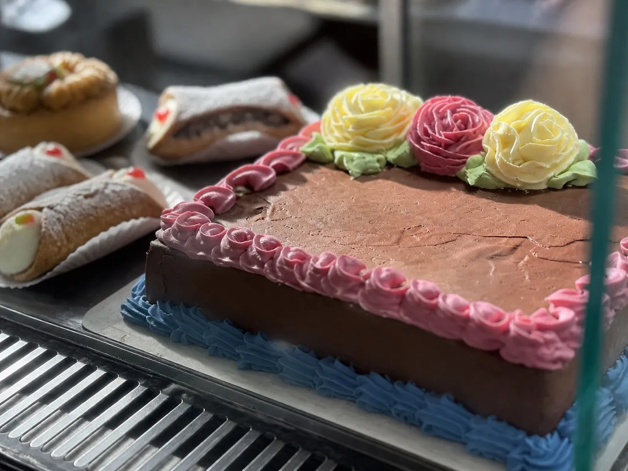 Iced cake and pastries on a bakery counter shelf