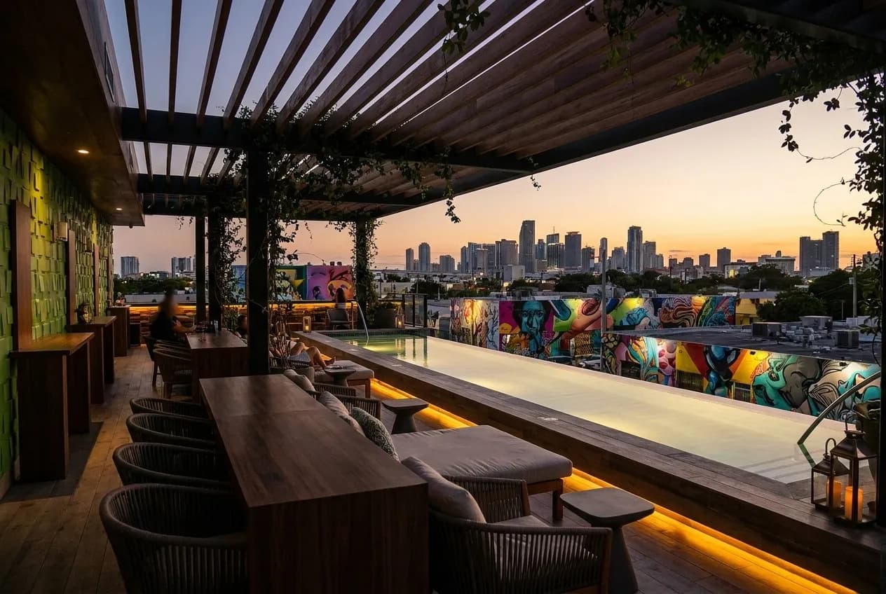 Seventh-floor rooftop pool deck at Amara Wynwood with lounge seating and Miami skyline visible in background at dusk