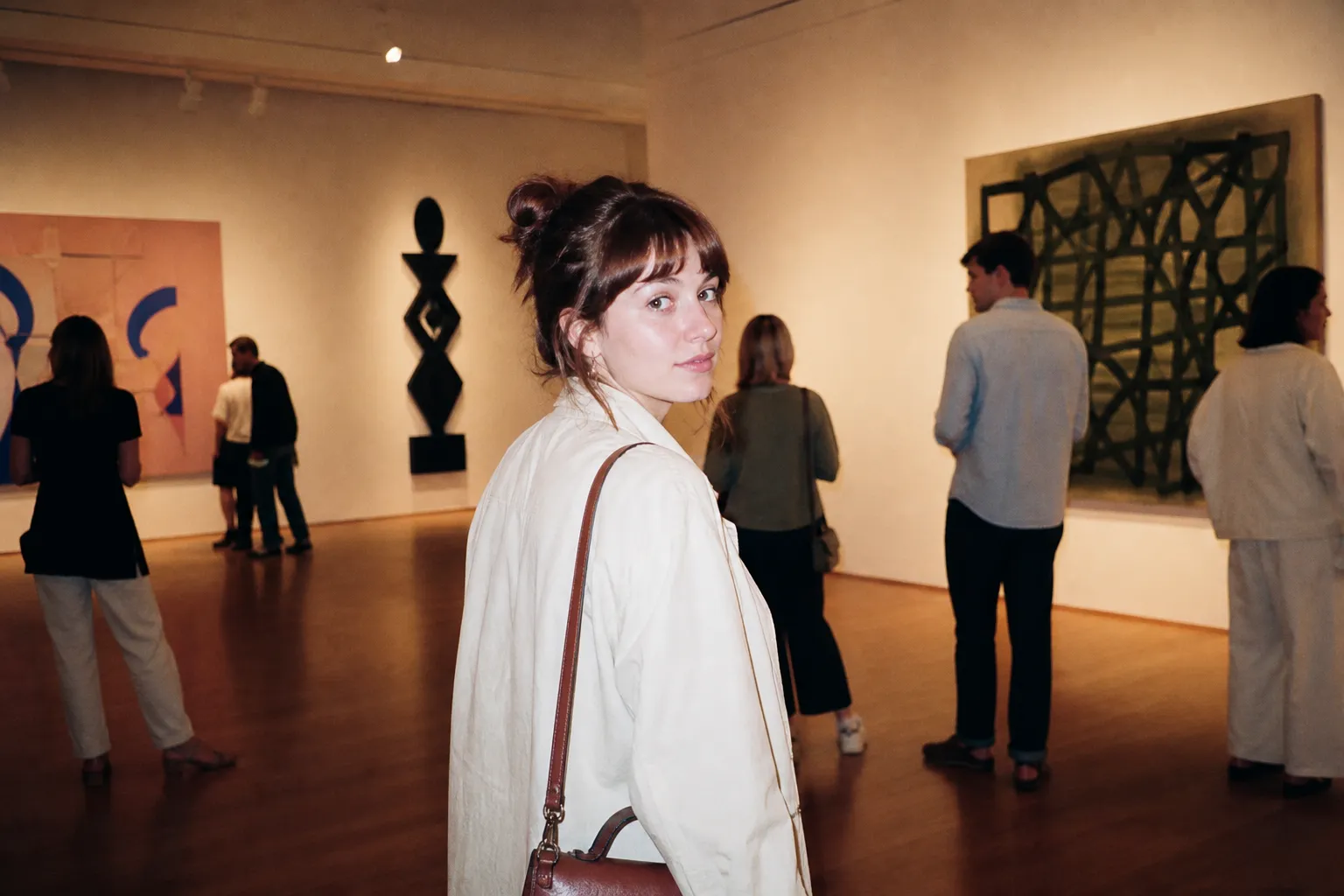 A spacious museum gallery with framed artwork along bright walls