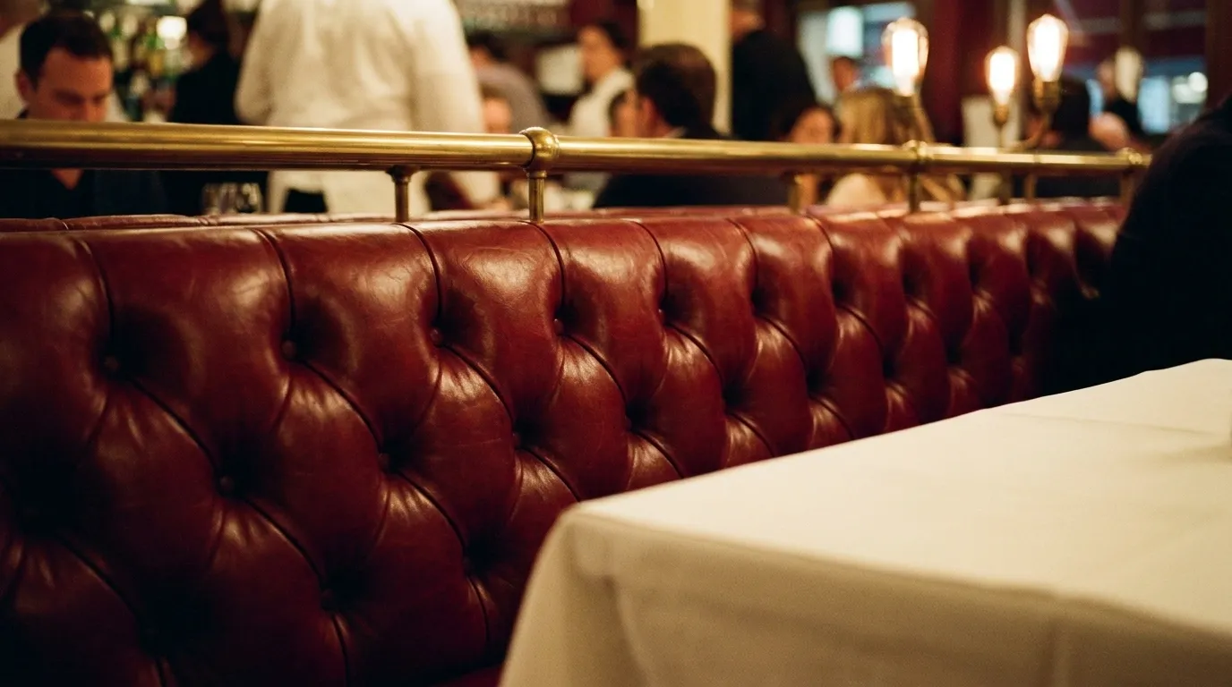 Close-up of red leather banquette seating in a traditional New York Italian restaurant with white tablecloth