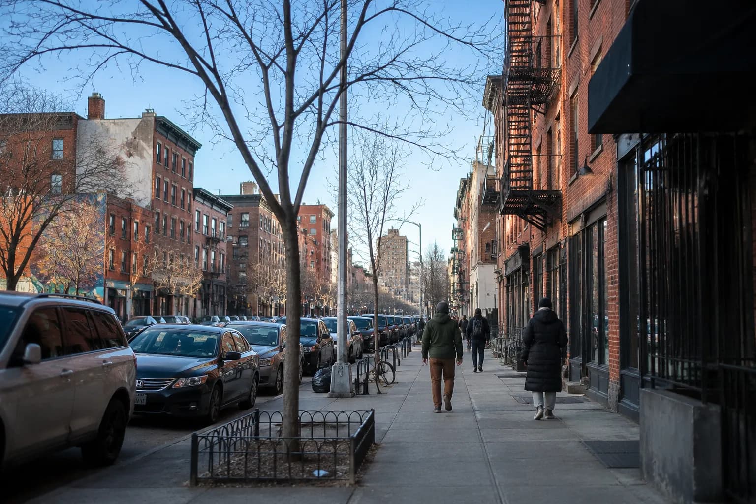 Manhattan Avenue in Greenpoint during daytime with storefronts and pedestrians on a clear afternoon
