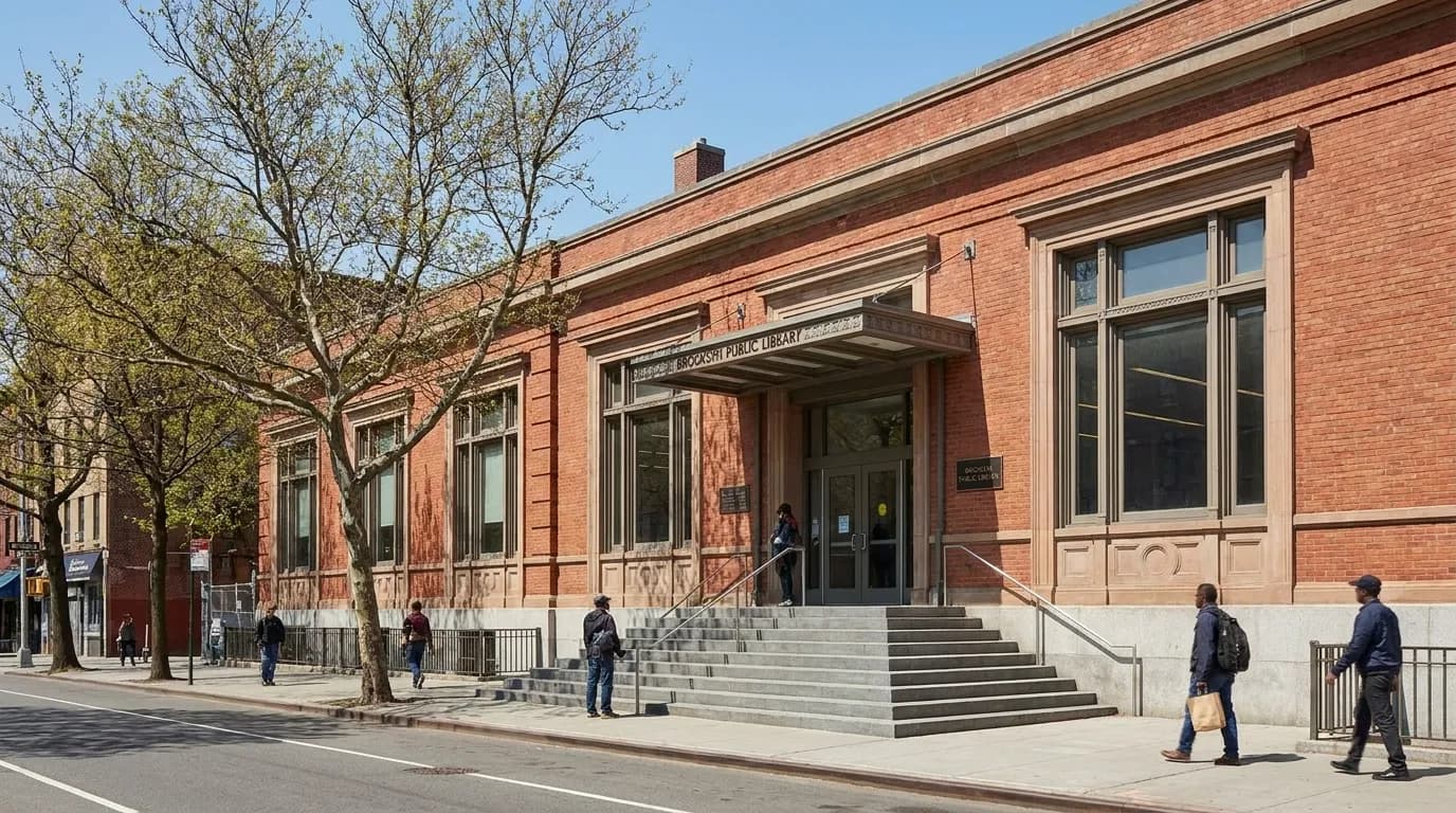 Exterior view of Sunset Park Library branch in Brooklyn, red brick building with front steps and street trees