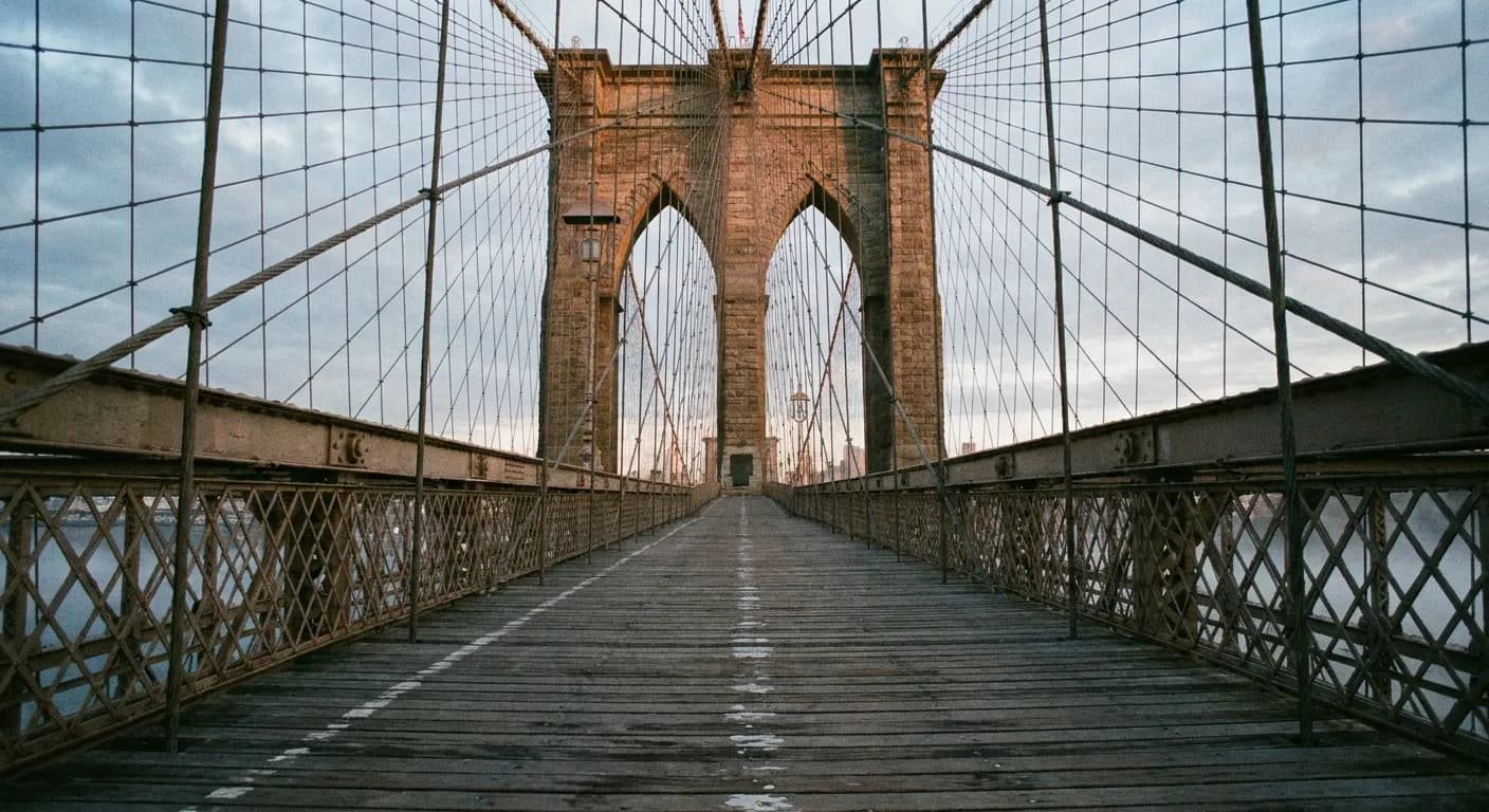 Stone towers and steel cables of a suspension bridge in early morning light