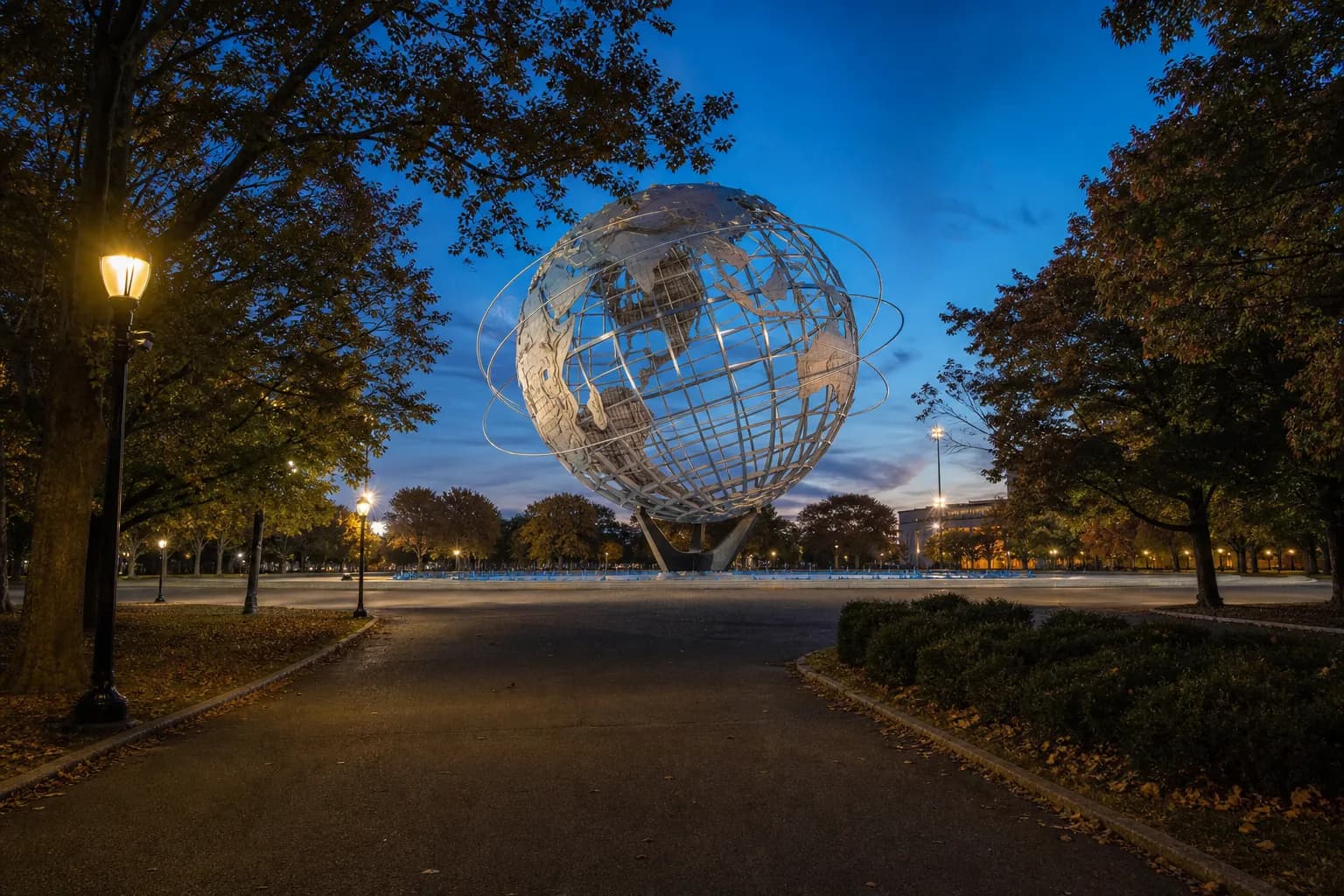 Flushing Meadows park landmark framed by paths and trees at blue hour