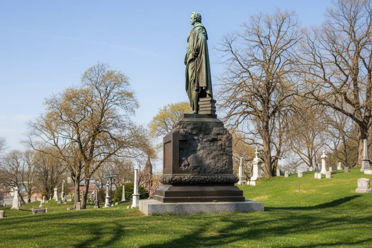 A 19th-century monument on a green cemetery hillside