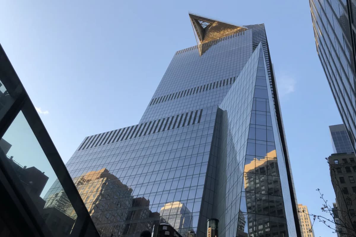 A glass skyscraper with a jutting observation deck