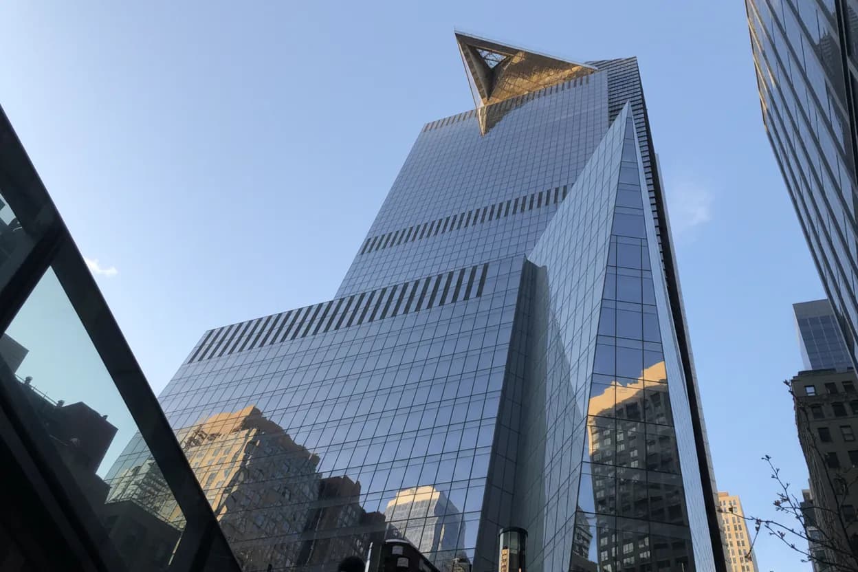 A glass skyscraper with a jutting observation deck