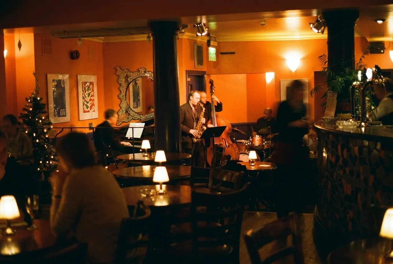 Musicians playing on a small stage in a low-lit New York jazz room