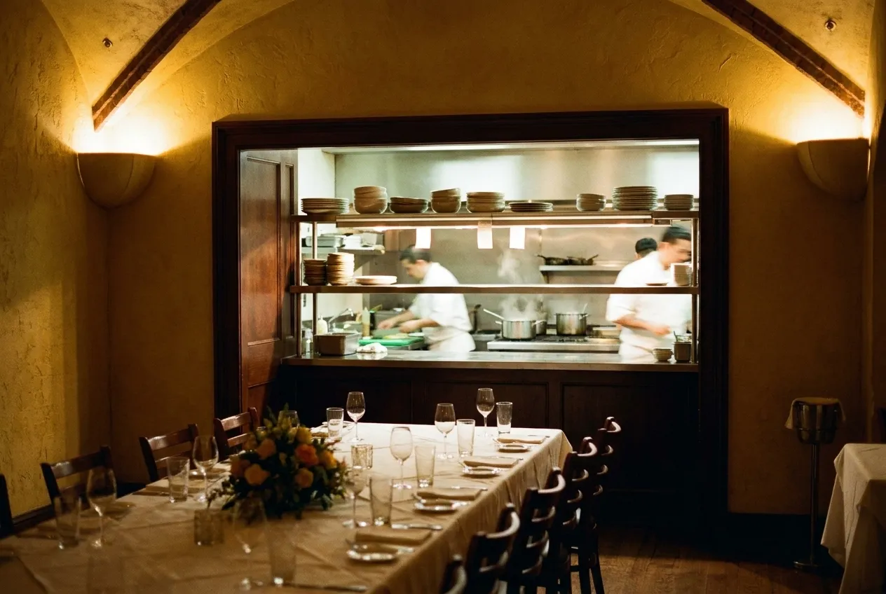 An open kitchen pass seen across a new dining room, service just beginning