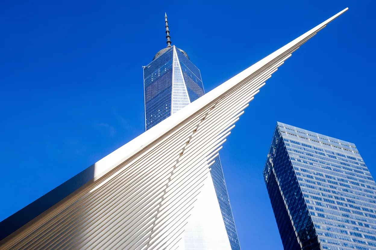 A dramatic white winged transit hub beside a skyscraper