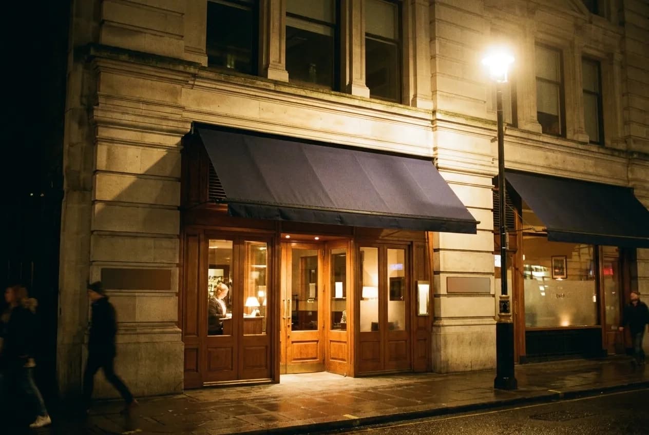 A restaurant doorway on a West Village corner, the host stand just visible inside