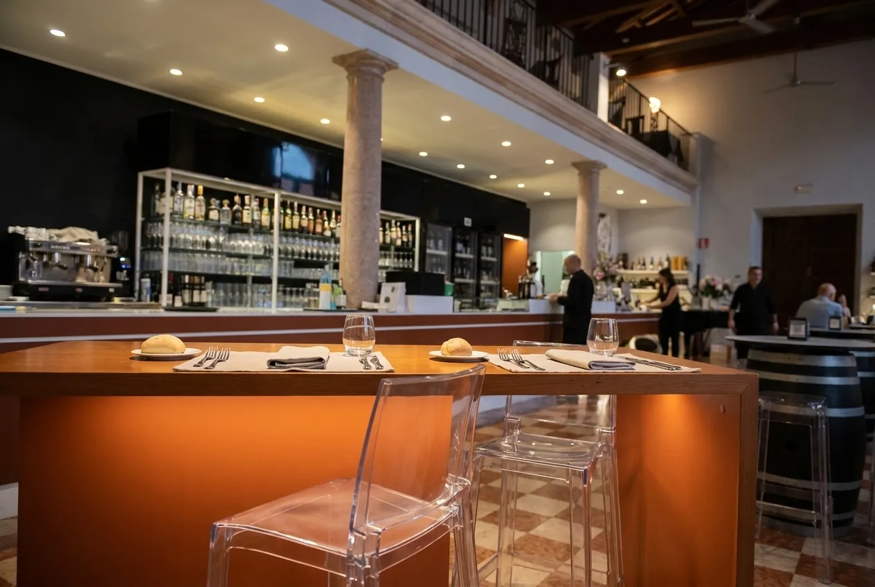 Two open stools at a restaurant bar, place settings already laid