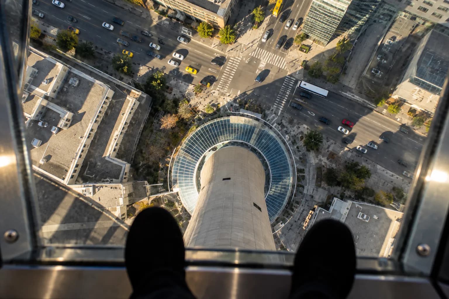 A view down through a glass floor to city streets far below