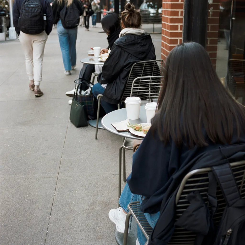 Greenwich Village sidewalk tables near campus during a fall lunch rush