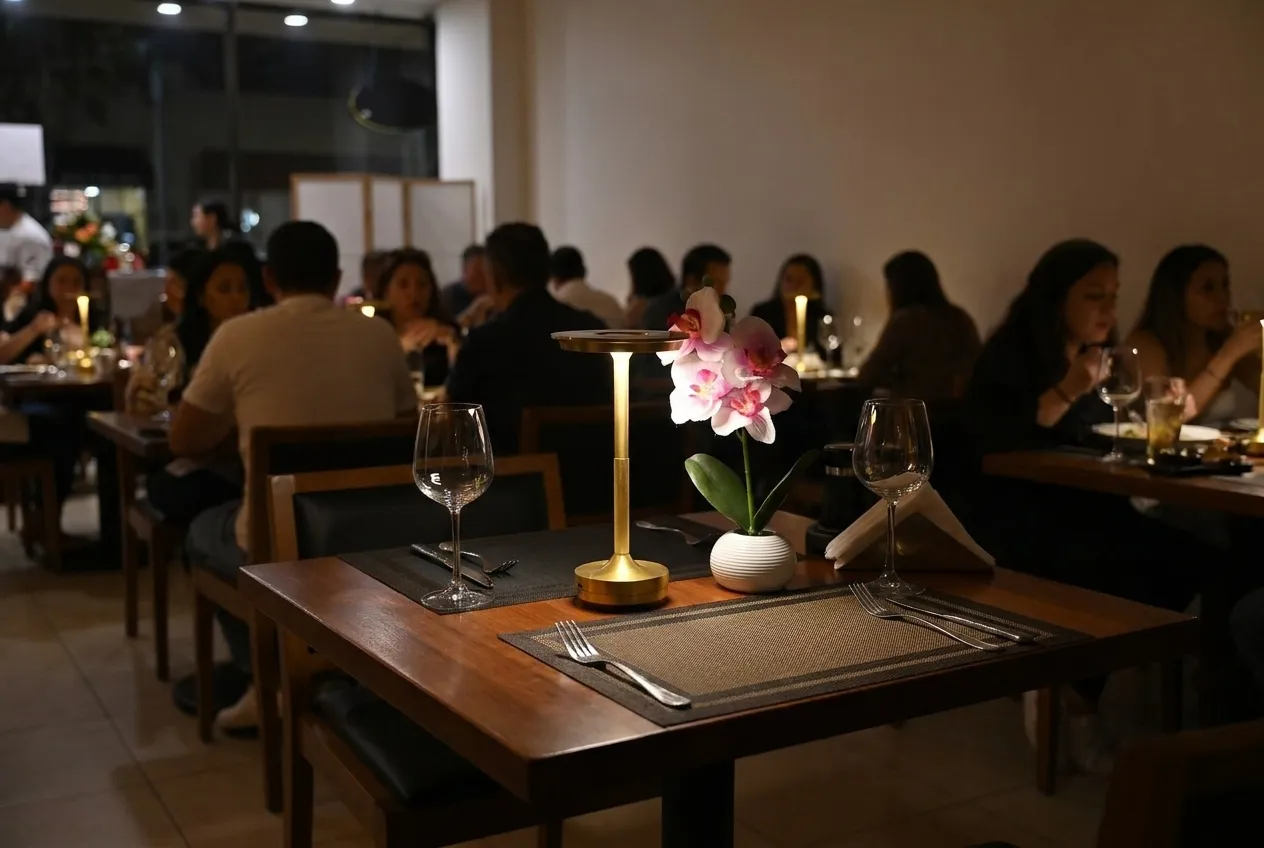An empty set table for two in an otherwise full dining room
