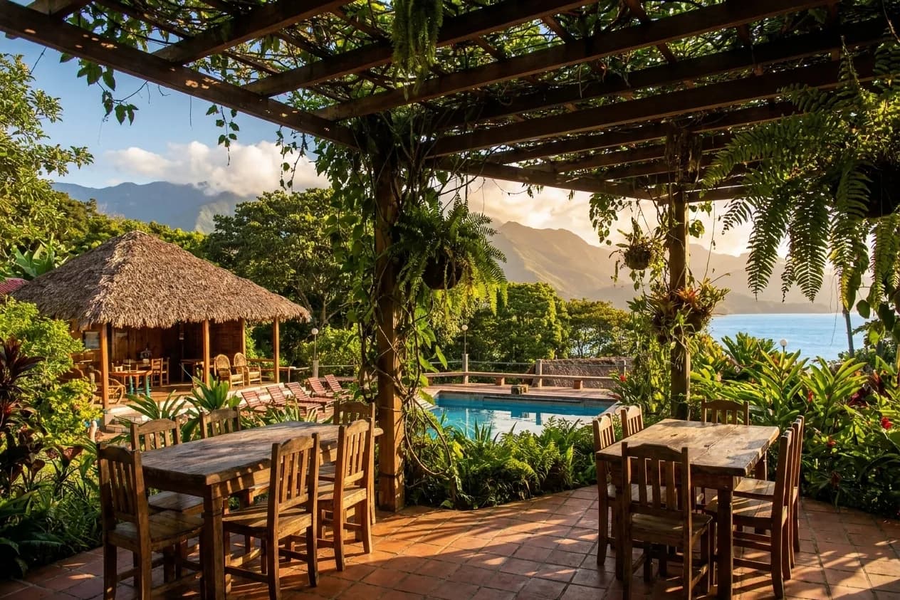 A shaded outdoor restaurant terrace with water visible beyond