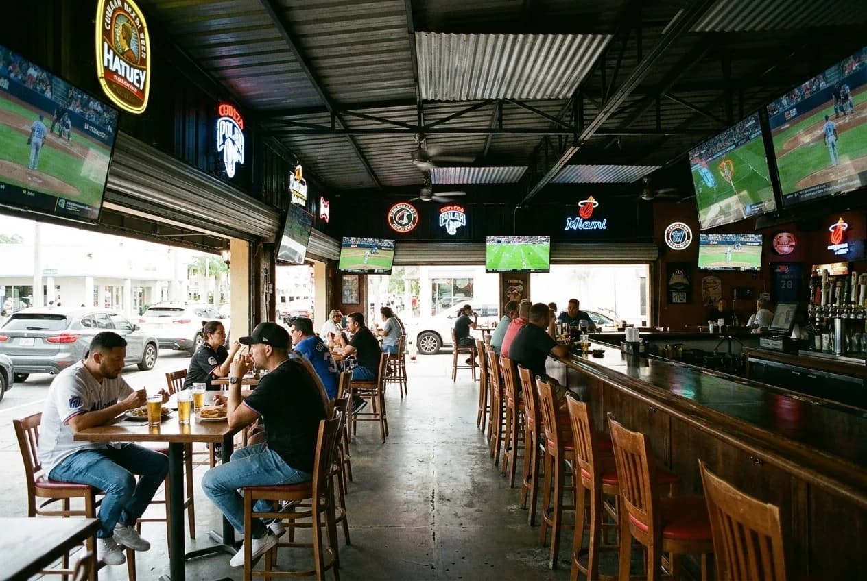 Interior of a Little Havana sports bar with televisions and seating for groups
