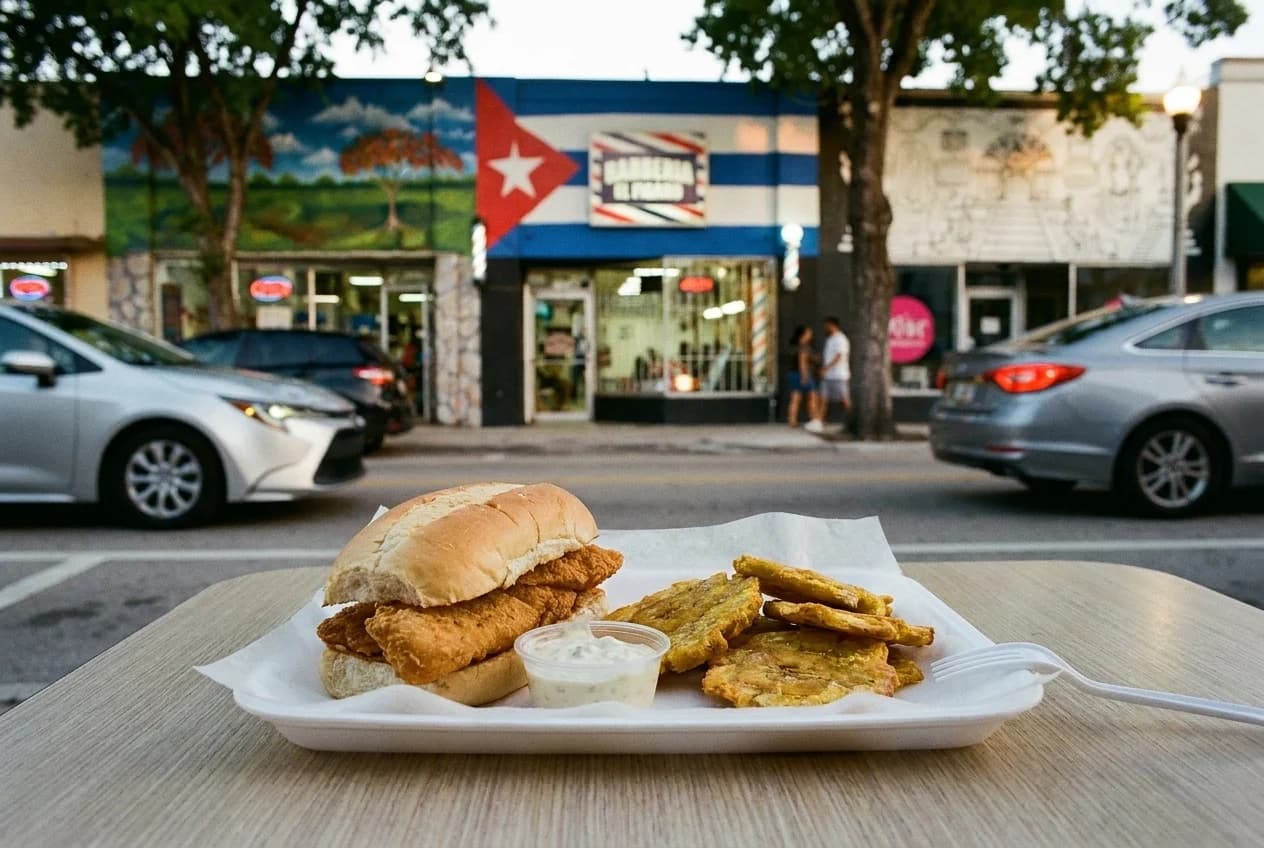 Fried fish sandwich with tostones on a plastic tray with wax paper and tartar sauce cup