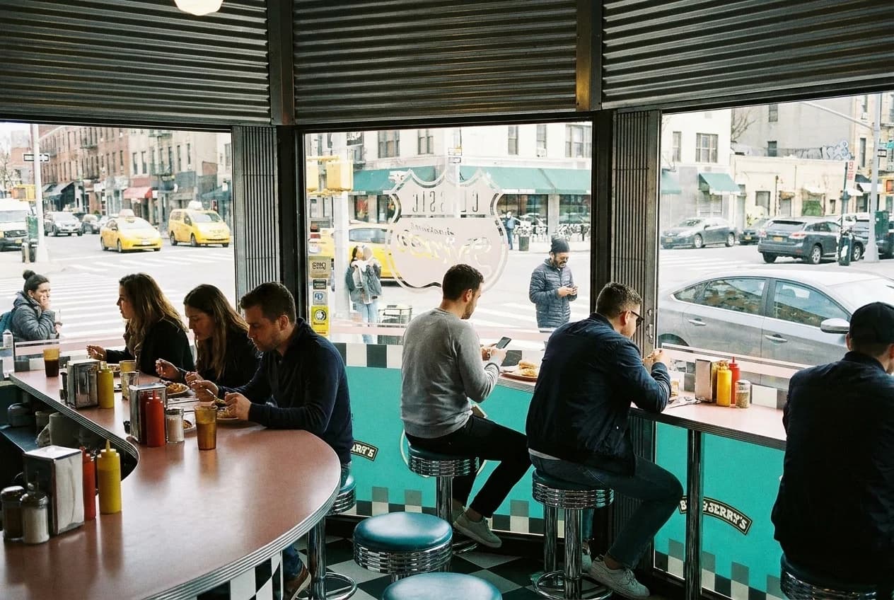 Classic diner lunch counter with chrome stools and street view through window