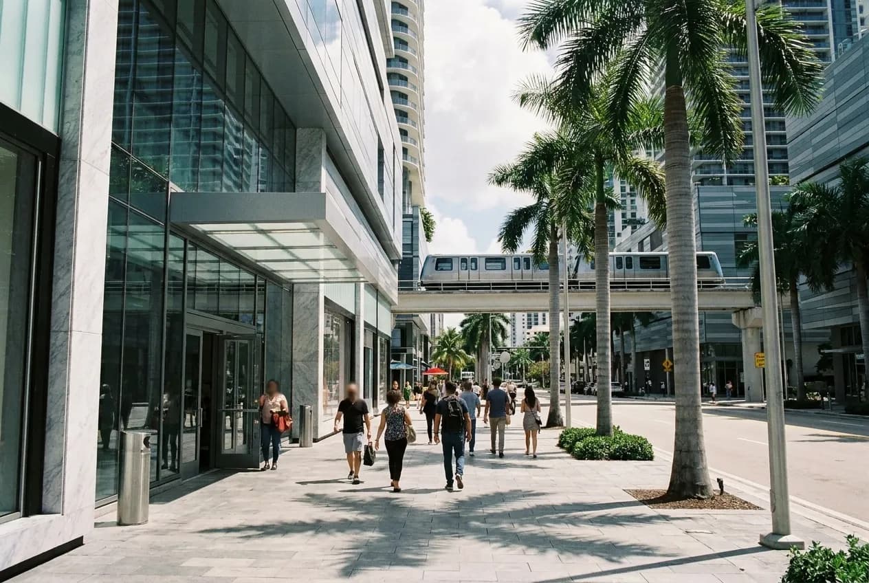 Wide view of South Miami Avenue in Brickell with Metromover train and modern buildings under afternoon sun.