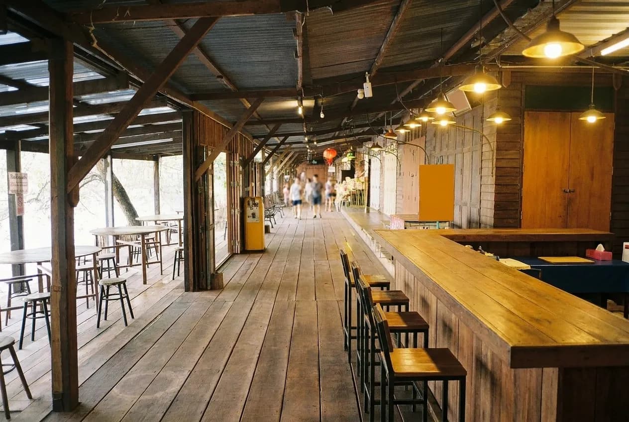 A restaurant bar with a few empty stools and a warm light above