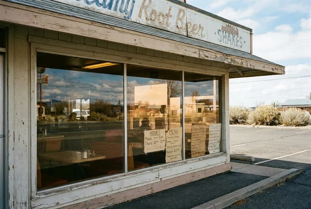 Hand-lettered restaurant signage and posted hours in a Los Angeles strip mall window