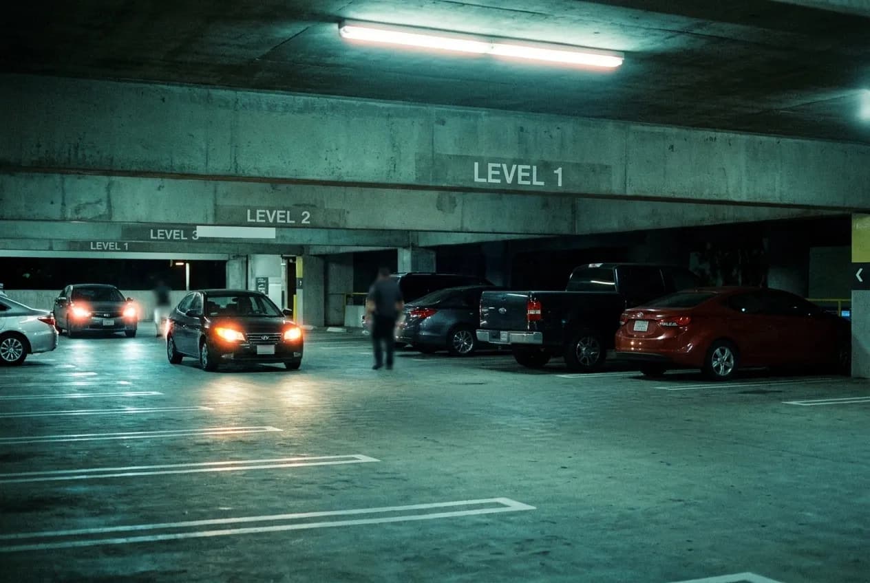 Entrance to a Los Angeles parking structure at night with cars and illuminated levels