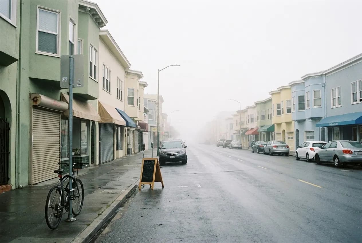 Low storefronts on a wide avenue in San Francisco's Outer Sunset under flat coastal fog