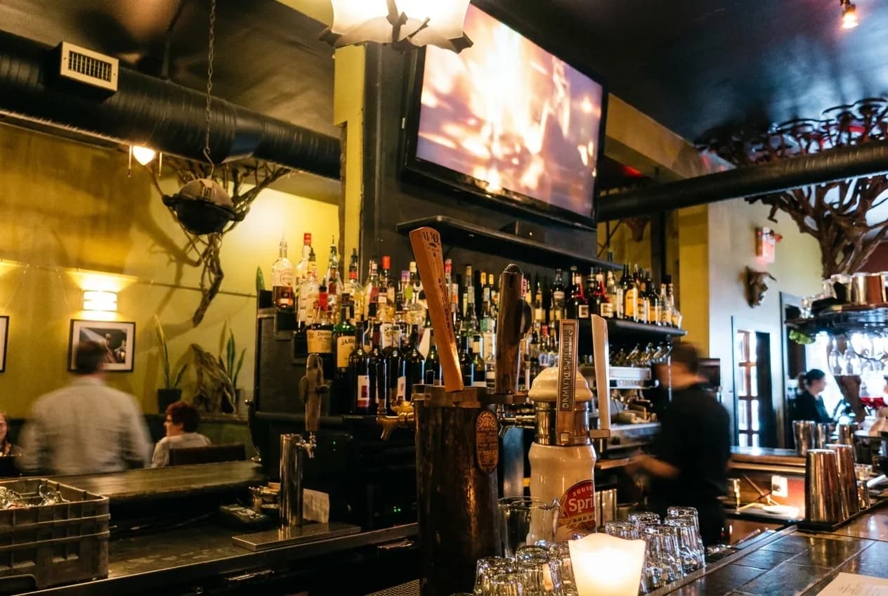 Television screen mounted above a bar in a late-night restaurant interior