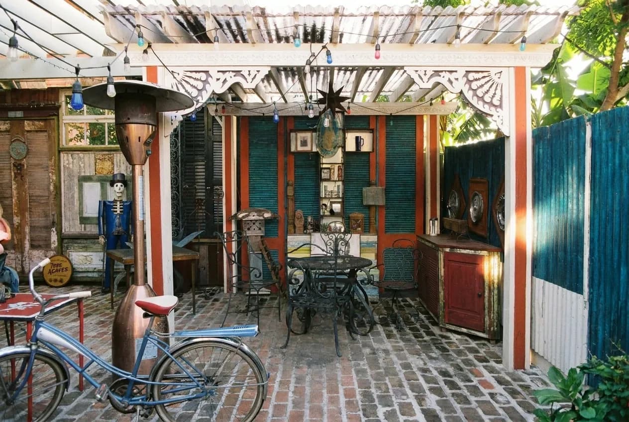 A sunlit restaurant courtyard in San Francisco with wooden tables and a high stucco wall
