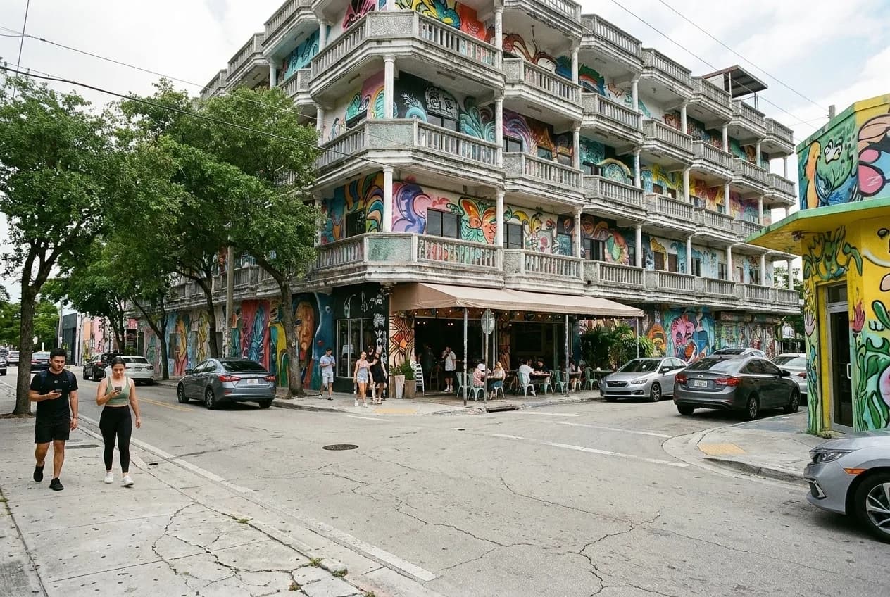 Tree-lined sidewalk on NW 25th Street in Wynwood with mural-painted buildings