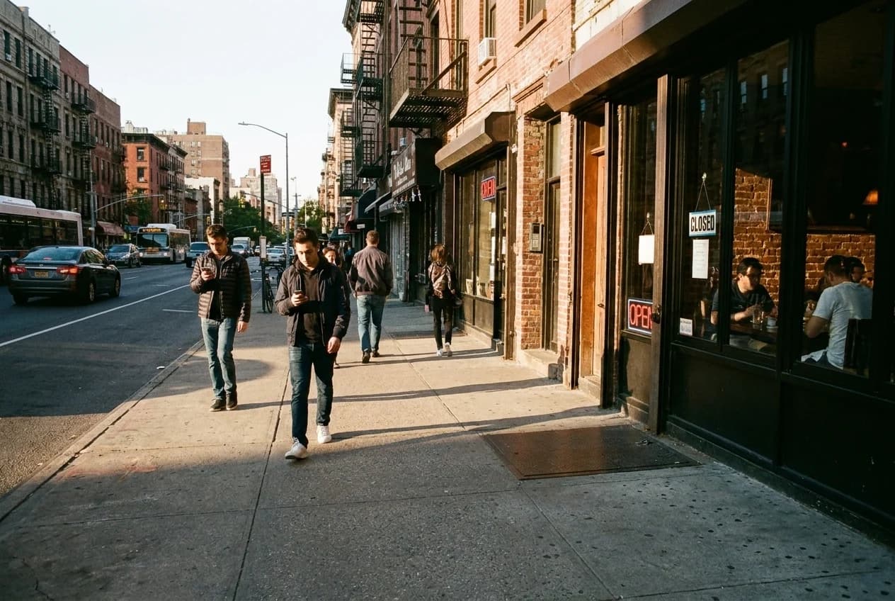 East 13th Street and First Avenue intersection in afternoon light, East Village storefronts and empty sidewalk visible