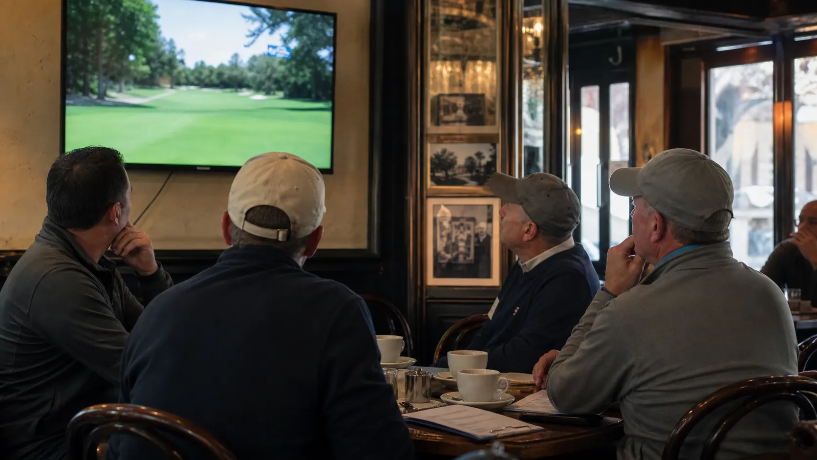 Golf fans in a New York City bar watch a tournament broadcast on television.
