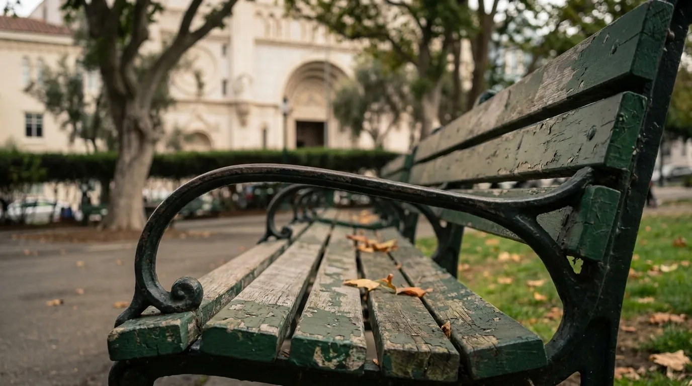 Weathered park bench in Washington Square Park with Saints Peter and Paul Church visible in the background