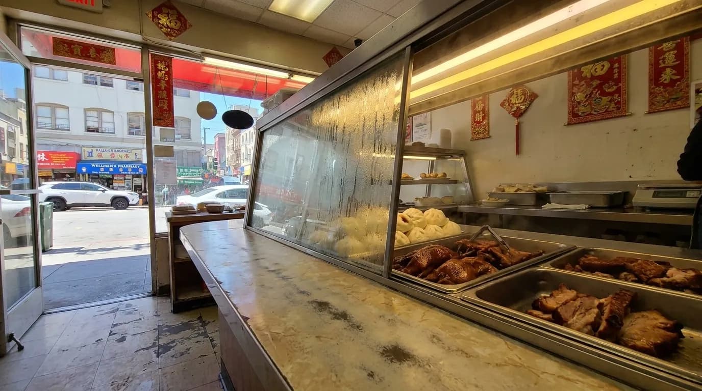 Formica counter at a Chinatown bakery in San Francisco with steam trays and baked goods behind glass