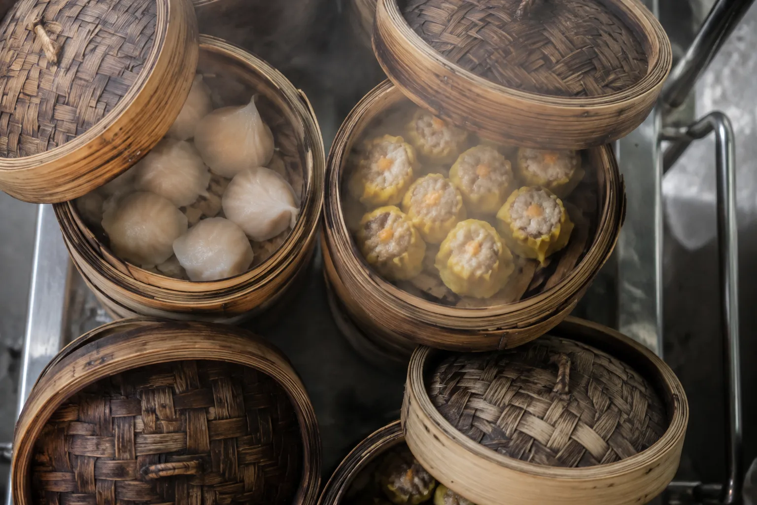 Bamboo steamer baskets stacked on a dim sum cart with dumplings visible inside