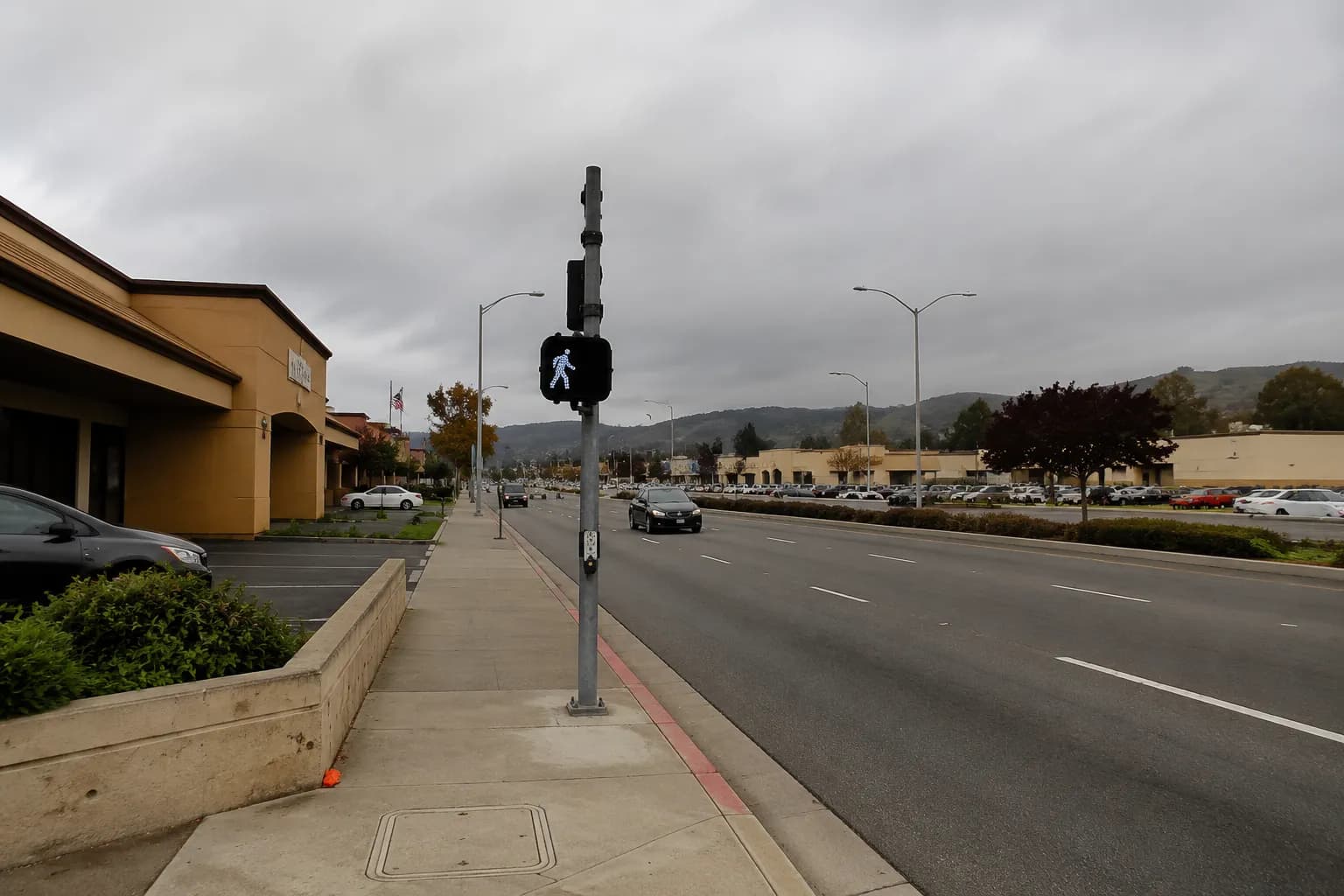 Wide intersection on Serramonte Boulevard in Colma with commercial buildings and parking lots