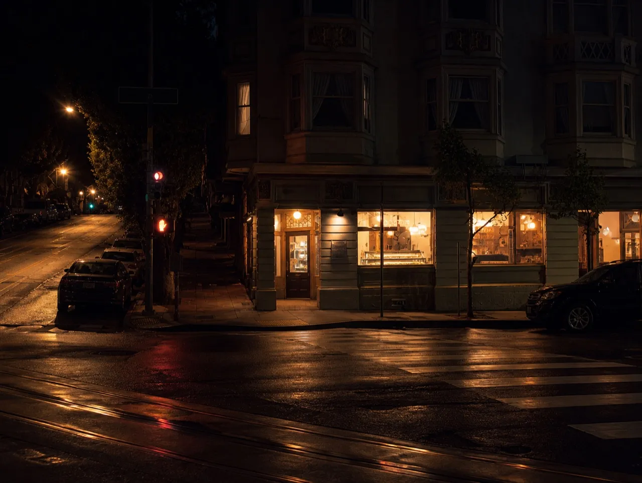 San Francisco bakery corner lit from inside in the early dark