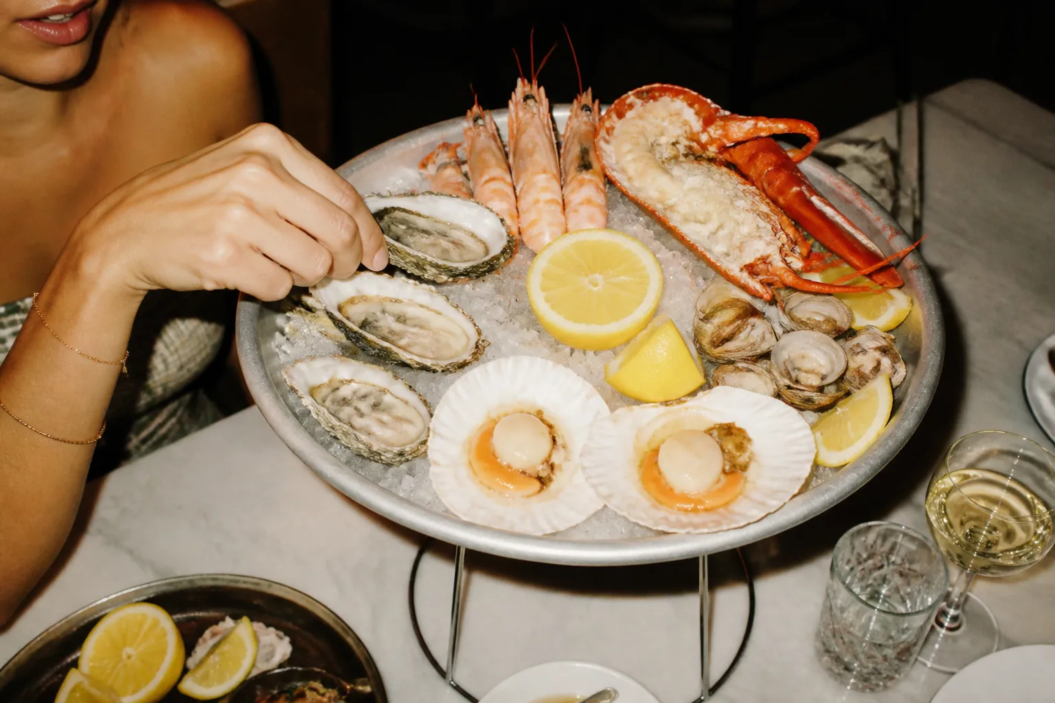 A fresh seafood platter with lemon wedges arranged on a bed of ice