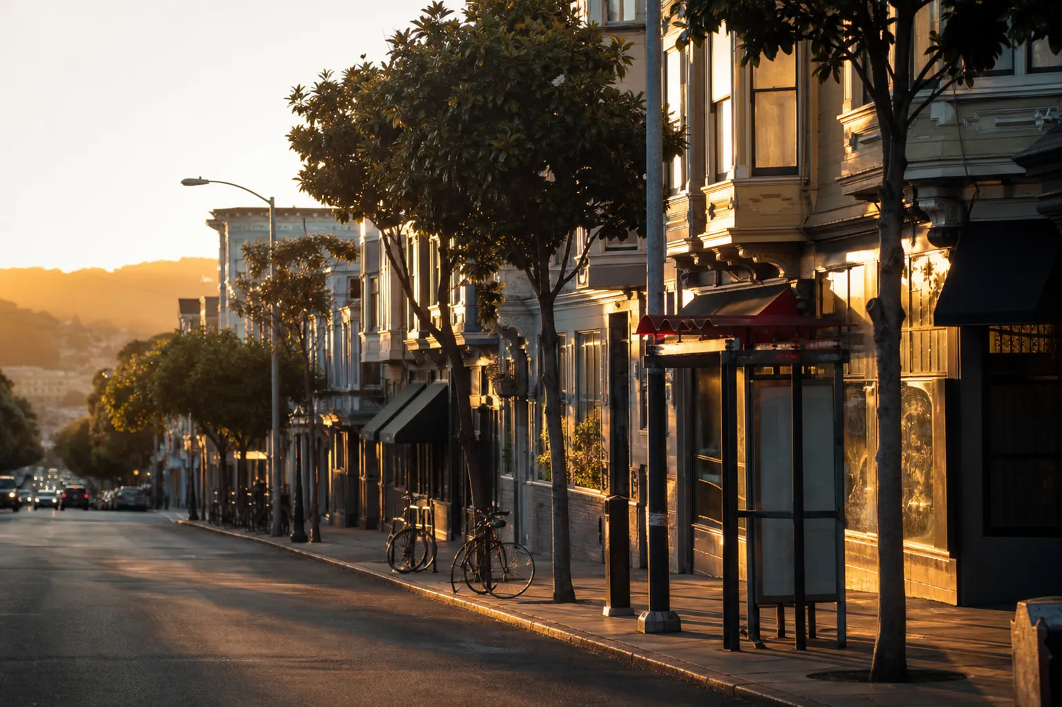 Divisadero Street commercial corridor in San Francisco's NoPa neighborhood at golden hour with low-rise storefronts and street trees