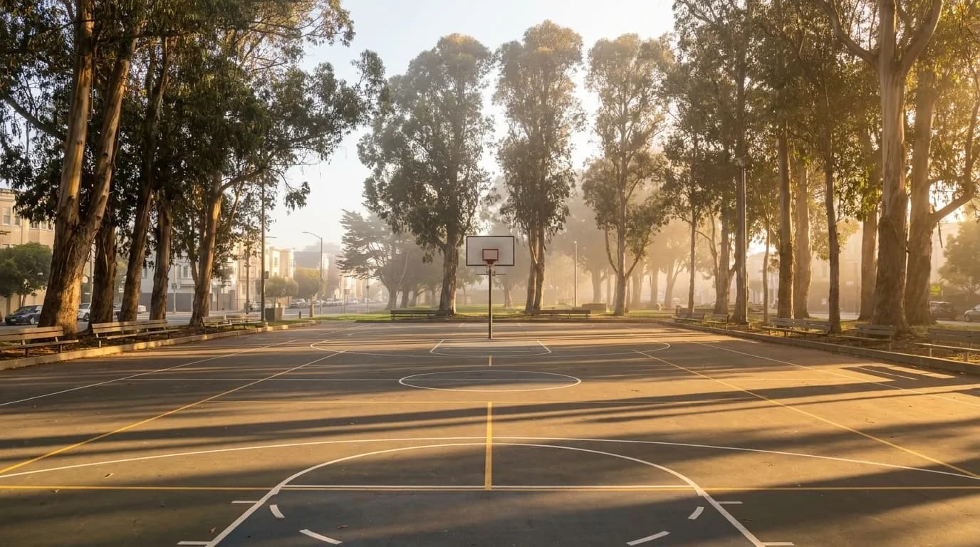 The Nate Thurmond basketball court at the Panhandle in San Francisco, surrounded by eucalyptus trees with Oak Street visible in the background