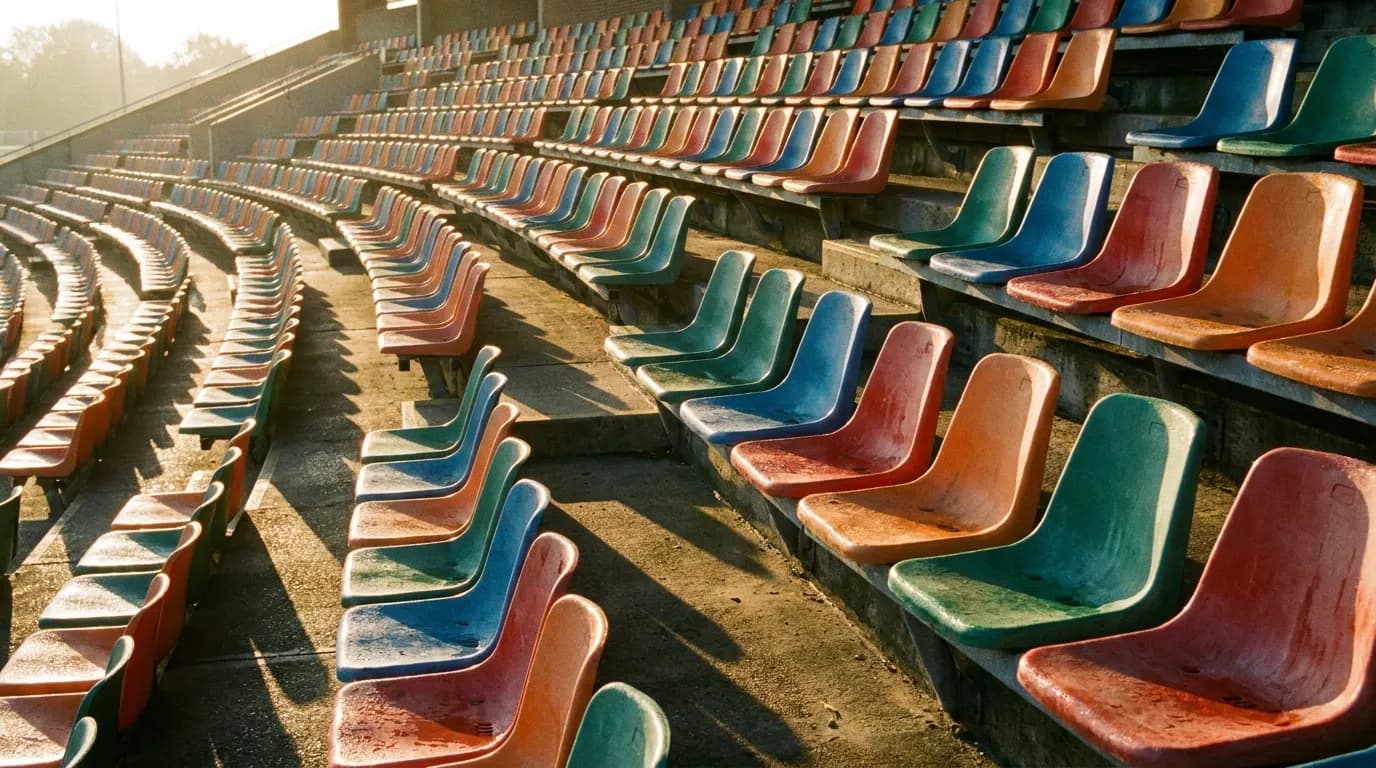 Morning sunlight streaming across empty stadium seats casting long shadows