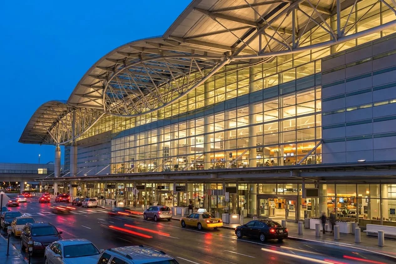 San Francisco International Airport International Terminal exterior at dusk with illuminated glass facade and terminal signage
