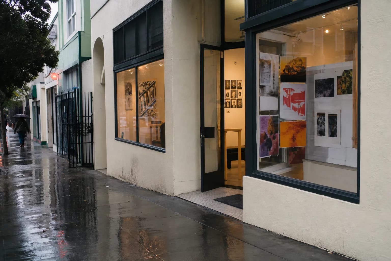 Rainy Valencia Street in San Francisco with murals, storefronts, and wet sidewalks