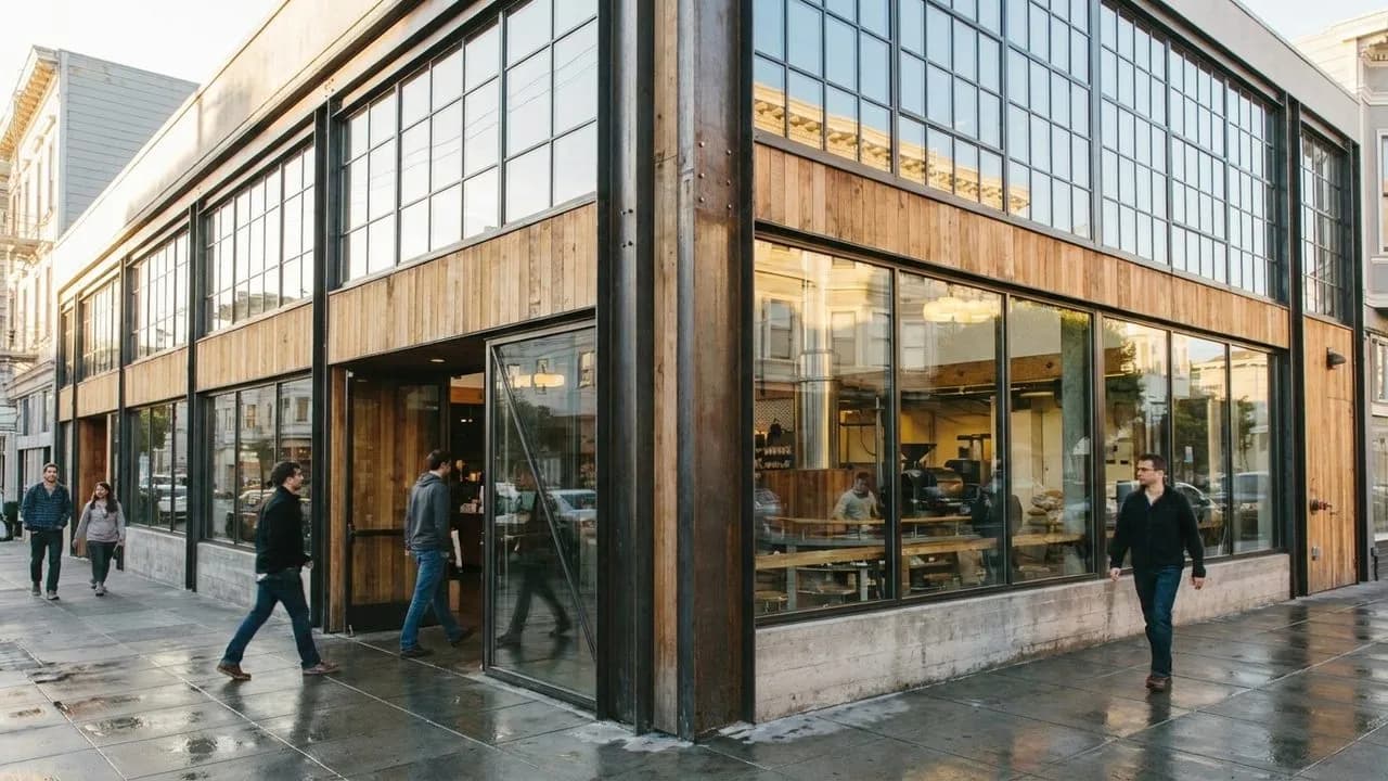 Sunlit warehouse coffee bar with glass frontage and pedestrians outside