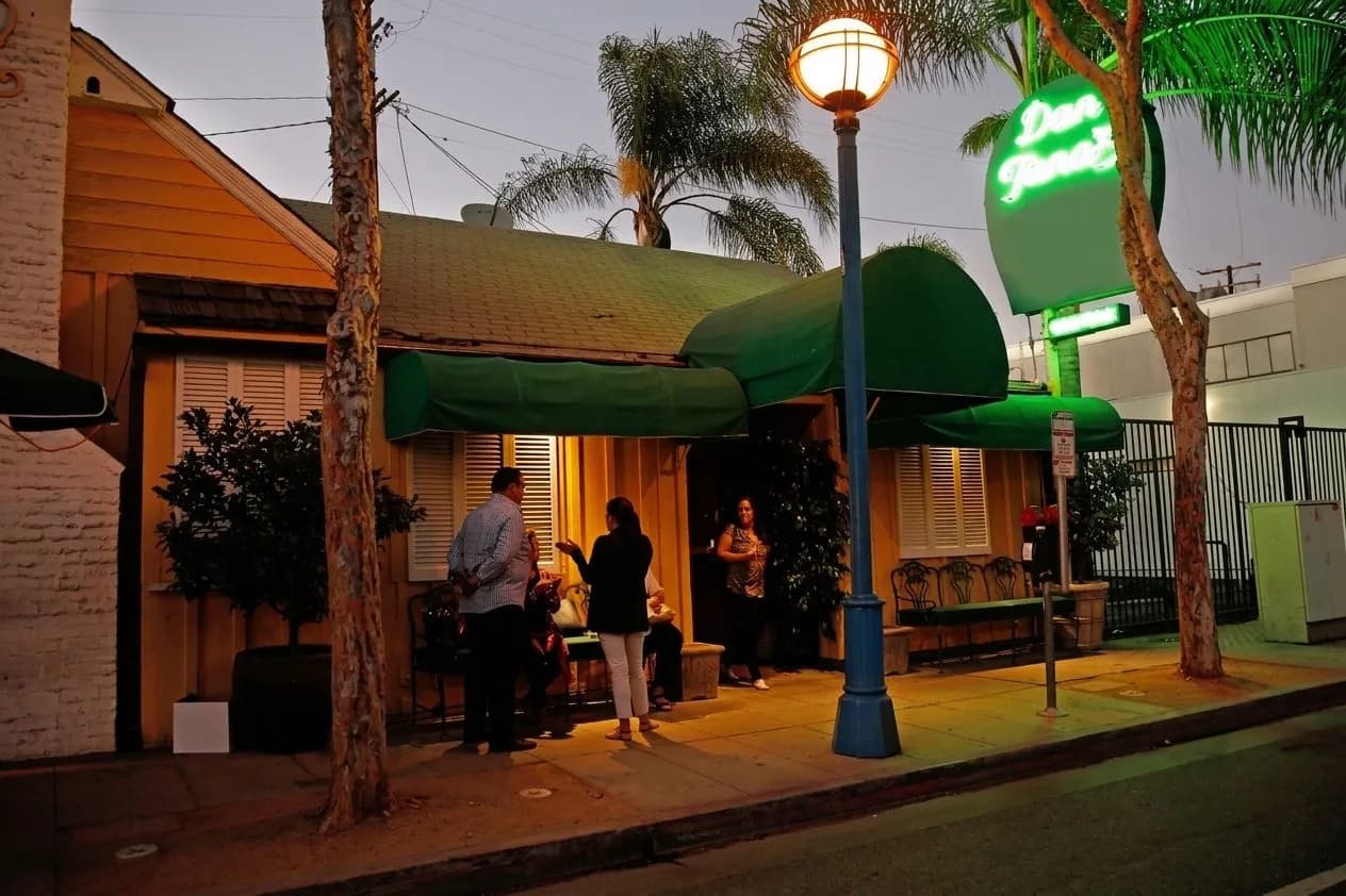 Exterior of a classic West Hollywood red-sauce restaurant glowing at dusk.